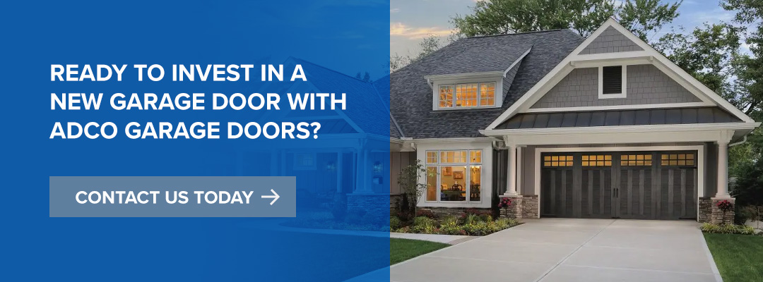 Grage door on the front of a home with a paved driveway and trees behind the home.